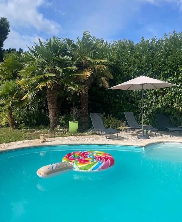 une piscine avec un flotteur coloré au milieu dans l'établissement La villa du manege, à La Celle-sous-Gouzon