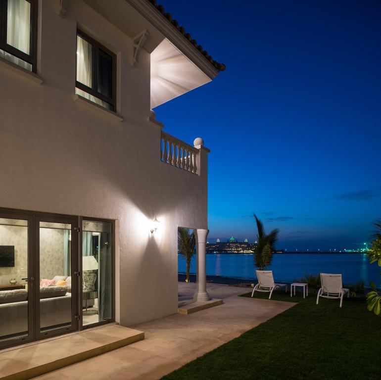 a house with a view of the ocean at night at Nasma Luxury Stays - Frond L, Palm Jumeirah in Dubai