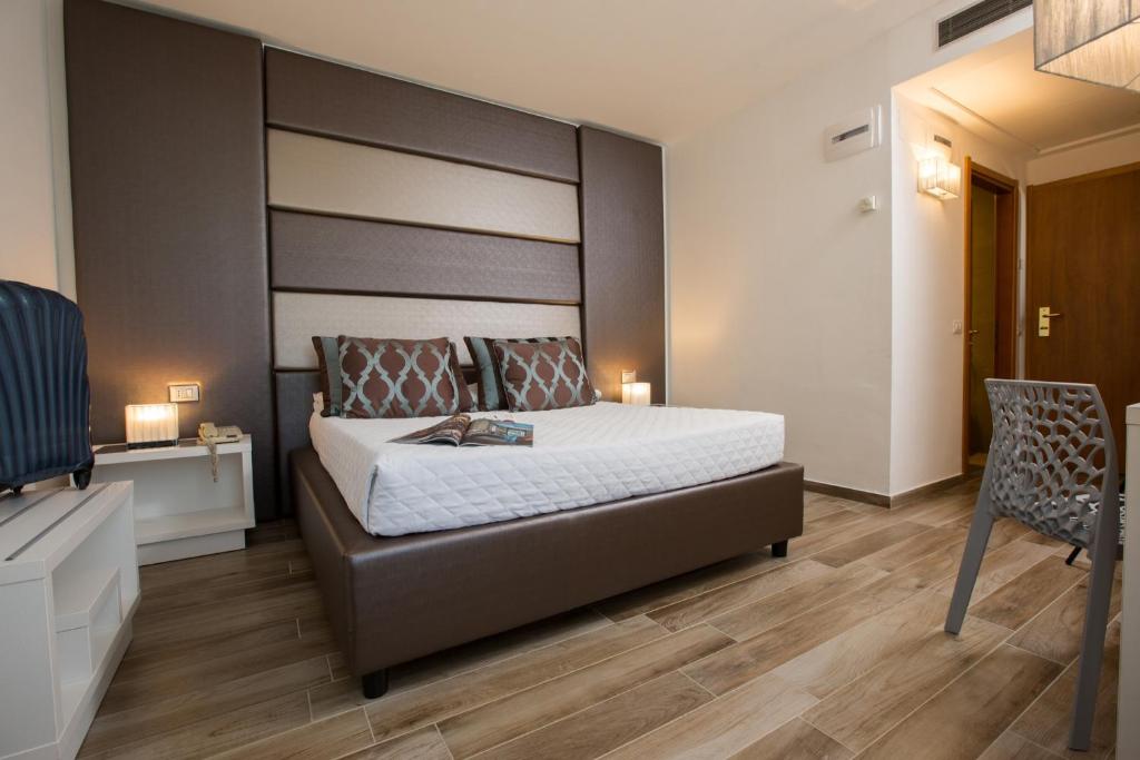 a bedroom with a large bed and a chair at Toscana Ambassador in Poggibonsi