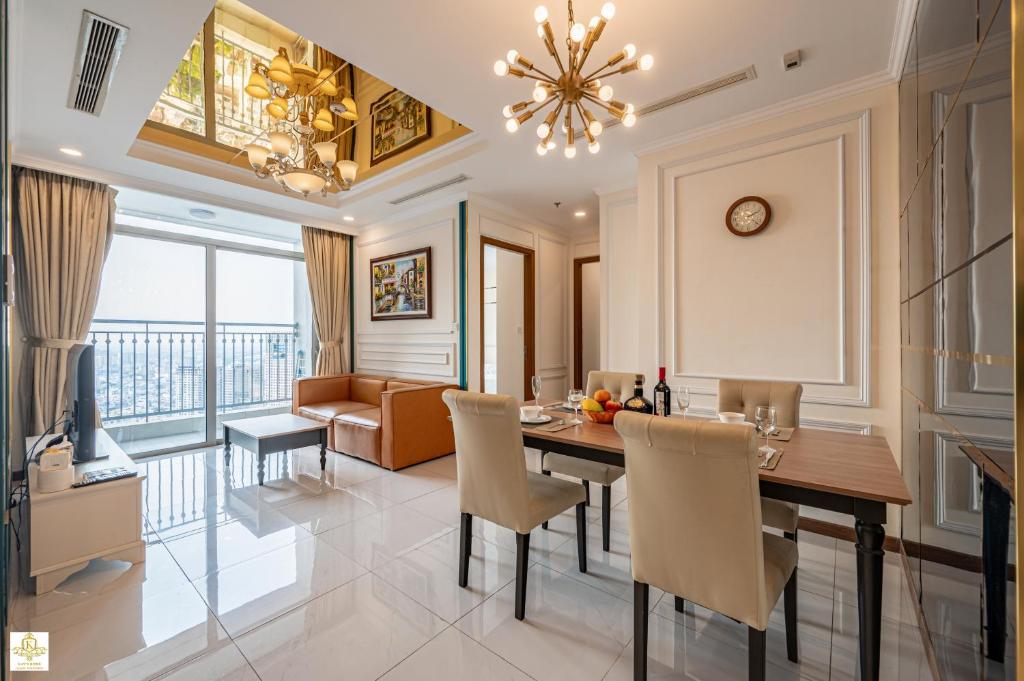 a dining room with a table and chairs and a couch at The Regal Residence at Vinhomes in Ho Chi Minh City