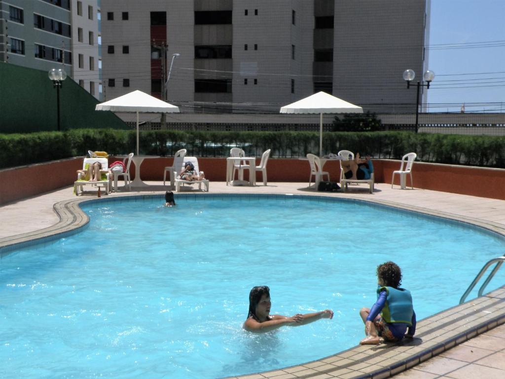 two women sitting in a swimming pool at ApartmentFortaleza Porto de Iracema in Fortaleza