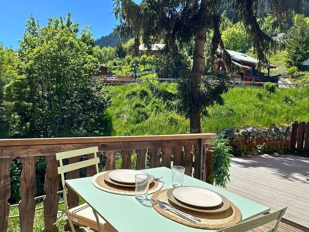 une table avec des chapeaux et des assiettes sur une terrasse dans l'établissement l'Ourson appartement central champagny la plagne, à Champagny-en-Vanoise