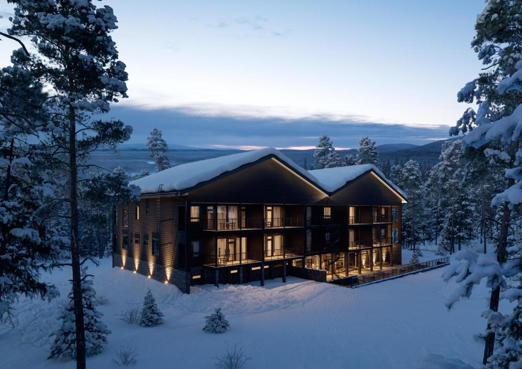 Ein Haus im Schnee im Wald in der Unterkunft Crest Chalet Ski-in Ski-out by Aavalevi in Levi