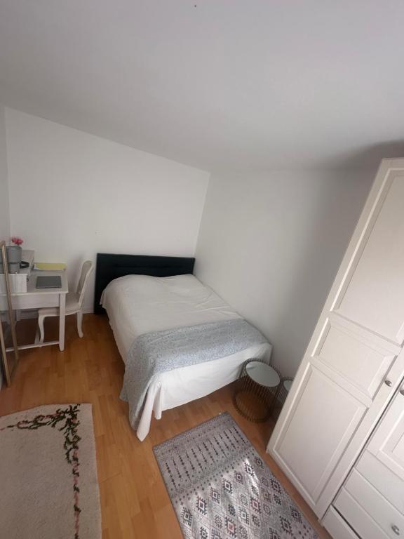 une petite chambre avec un lit et une table dans l'établissement La rechelaise, à La Rochelle