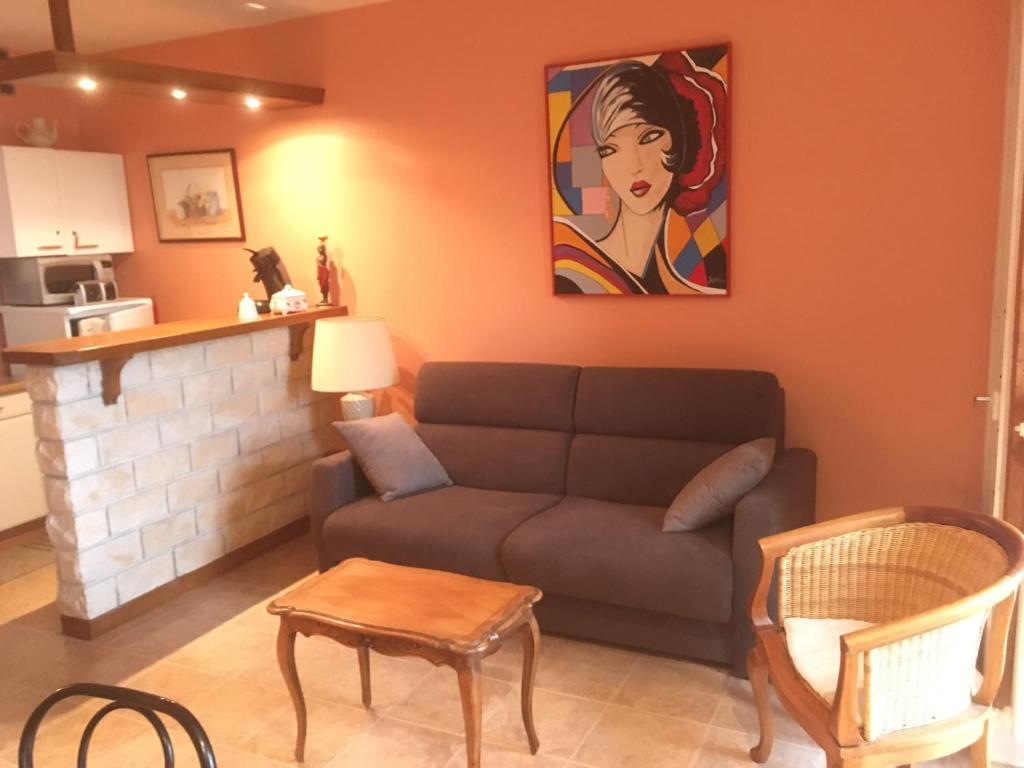 a living room with a couch and a painting on the wall at Appartement dernier étage, très belle vue - Centre-ville in Vichy