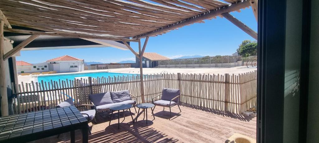 une vue sur un patio avec des chaises et une piscine dans l'établissement PISCINE CHAUFFEE, Vue imprenable Grand studio 4P Coudalère, au Barcarès