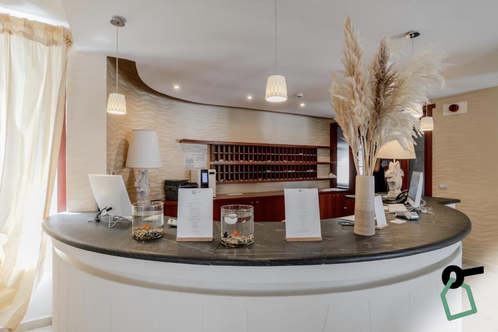 a lobby with a round table with glasses and flowers at HOTIDAY Room Collection - Mattinata Faraglioni in Mattinata