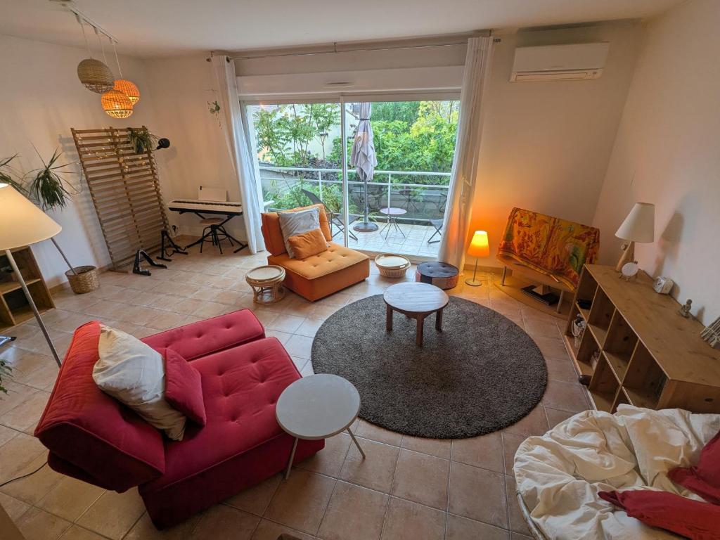 un salon avec un canapé rouge et une table dans l'établissement Jolie maison sportive avec extérieurs, à Millau