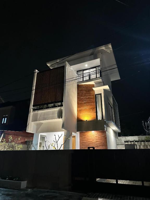 a tall white building at night with its lights on at Villa Mecca in Batu