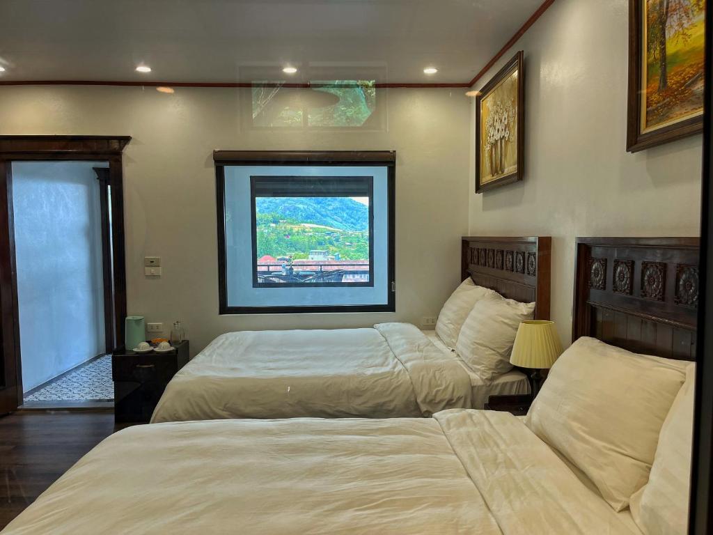 サパにあるWhisper Stay I The Hillside Villaのベッドが2つと窓があるホテルの部屋