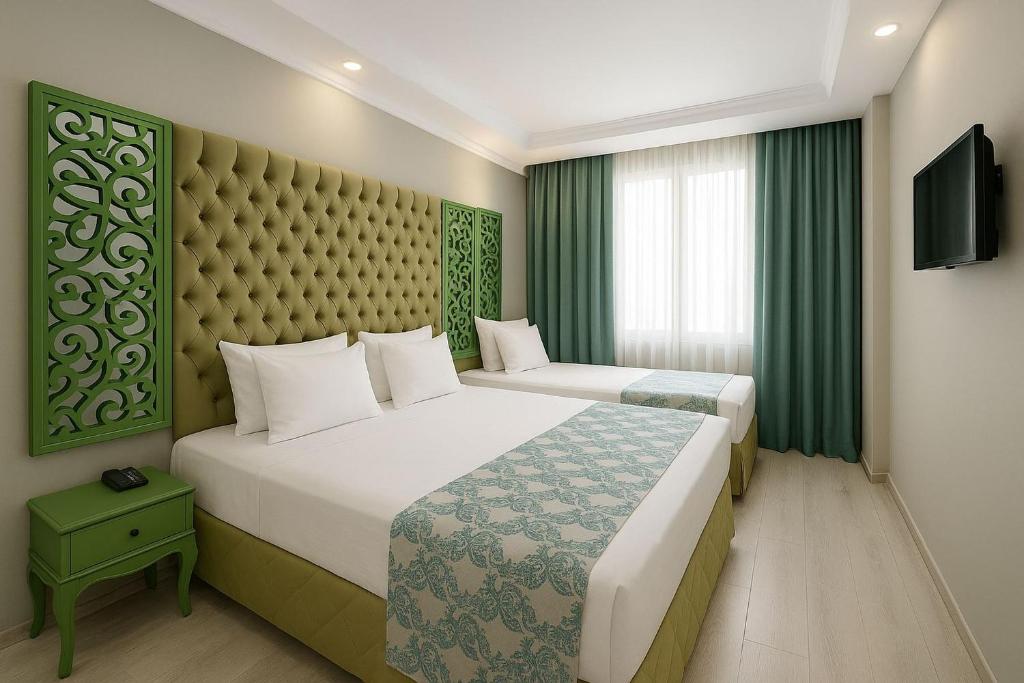two beds in a hotel room with green curtains at Green Garden Hotel - Bahçelievler in Istanbul