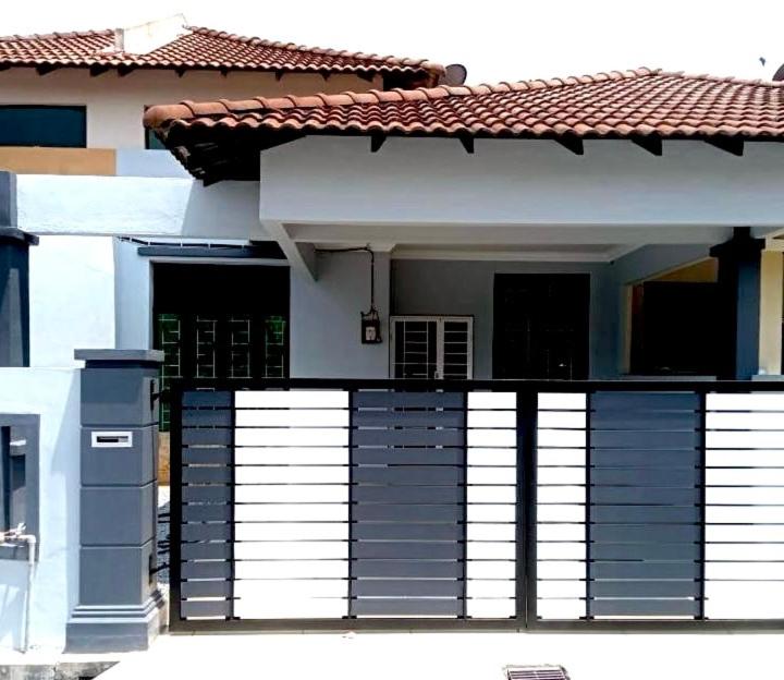 a white house with a black and white balcony at Arrafah Homestay Klebang in Tranquerah