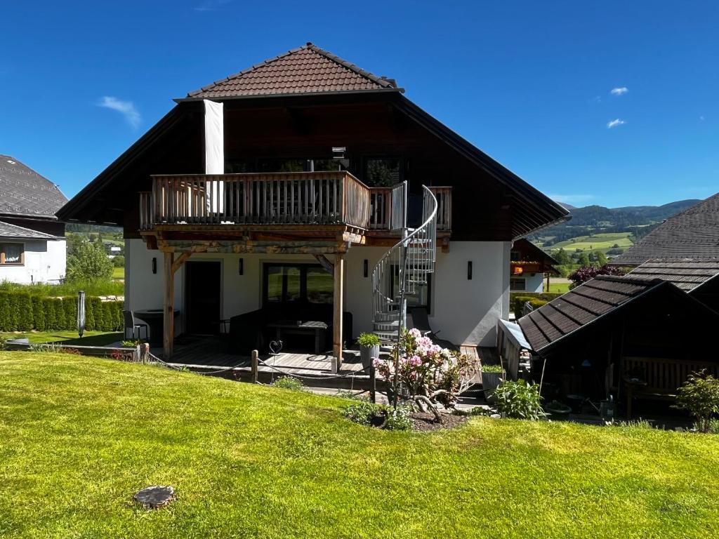 une maison avec un balcon au-dessus d'une cour dans l'établissement Stunning Luxury Holiday Accommodation, Sleeps 4, Living Room, Kitchen, Games Room and Bar, à Mörtelsdorf