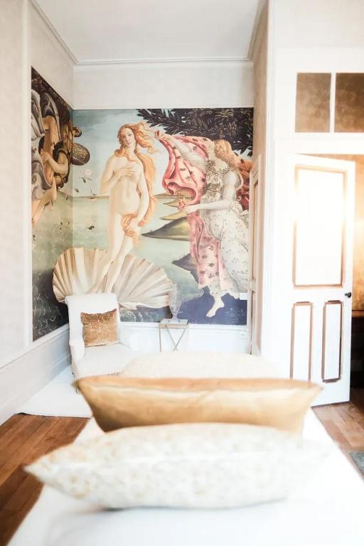 une chambre avec un mur orné de peintures. dans l'établissement Chateau De Londigny & Spa Retreat, à Londigny