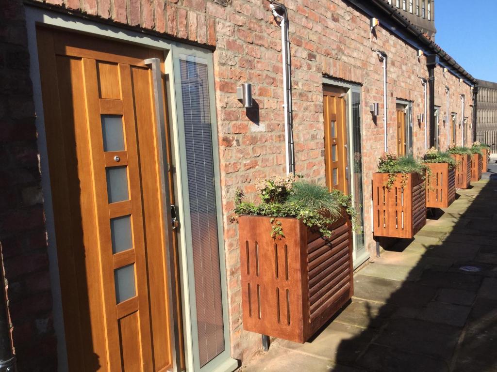 a brick building with a door and potted plants at York Aparthotel in York