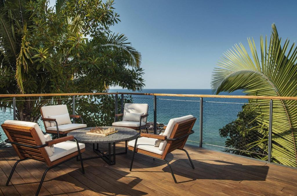 a patio with chairs and a table and the ocean at One&Only Mandarina in Lo de Marcos