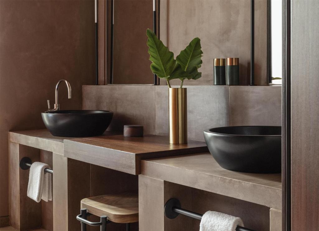 a bathroom with two sinks and a potted plant at One&Only Mandarina in Lo de Marcos