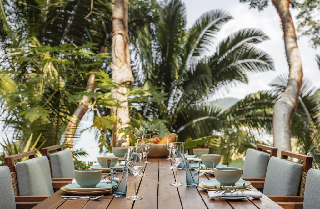 a wooden table with plates and glasses on it at One&Only Mandarina in Lo de Marcos