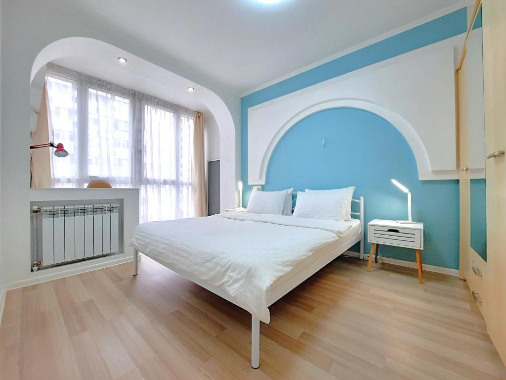 ein Schlafzimmer mit einem großen Bett mit einem Bogen darüber in der Unterkunft Двокімнатна студія з 3 ліжками Мережа AlexApartments Документи для відряджень Безконтатне заселення 24-7 in Shcherbani