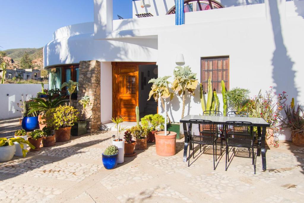 a patio with a table and chairs and potted plants at Casa Sol, Rodalquilar in Rodalquilar