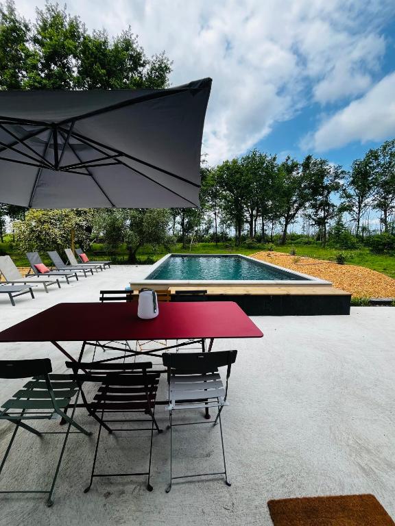 - une table et des chaises avec un parasol et une piscine dans l'établissement La Casa M, à Sainte-Hélène