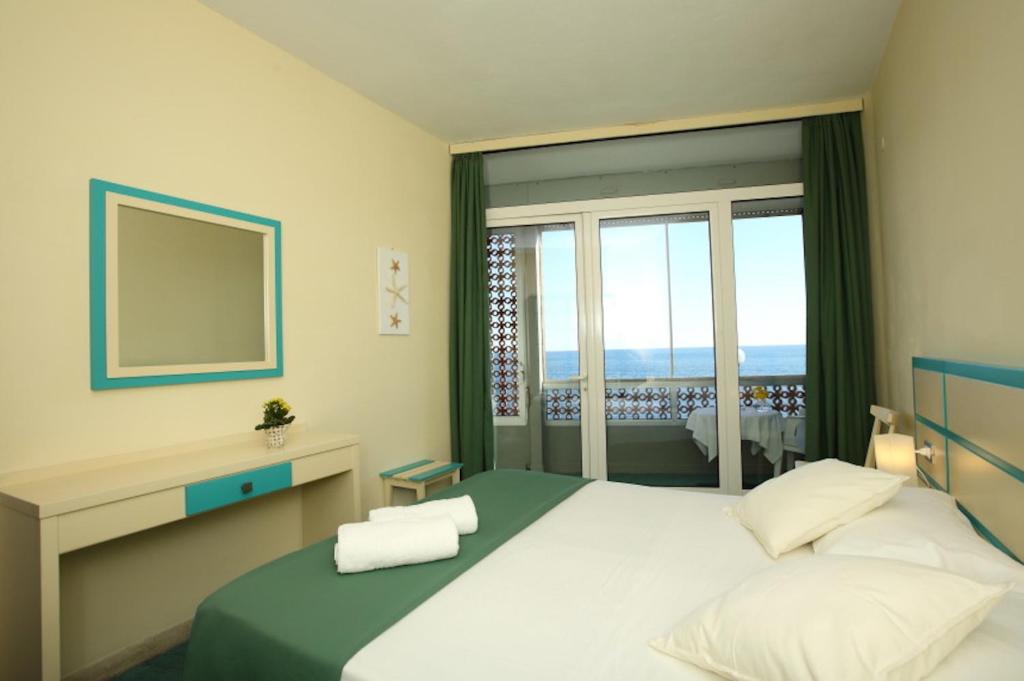 Postel nebo postele na pokoji v ubytování Hotel La Scogliera