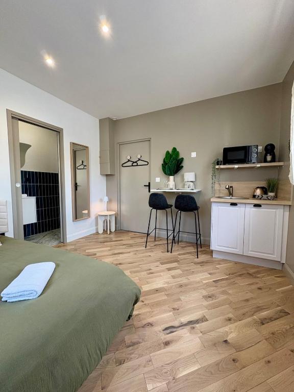 une chambre avec un lit et une cuisine avec une table dans l'établissement Le Studio, à Anstaing