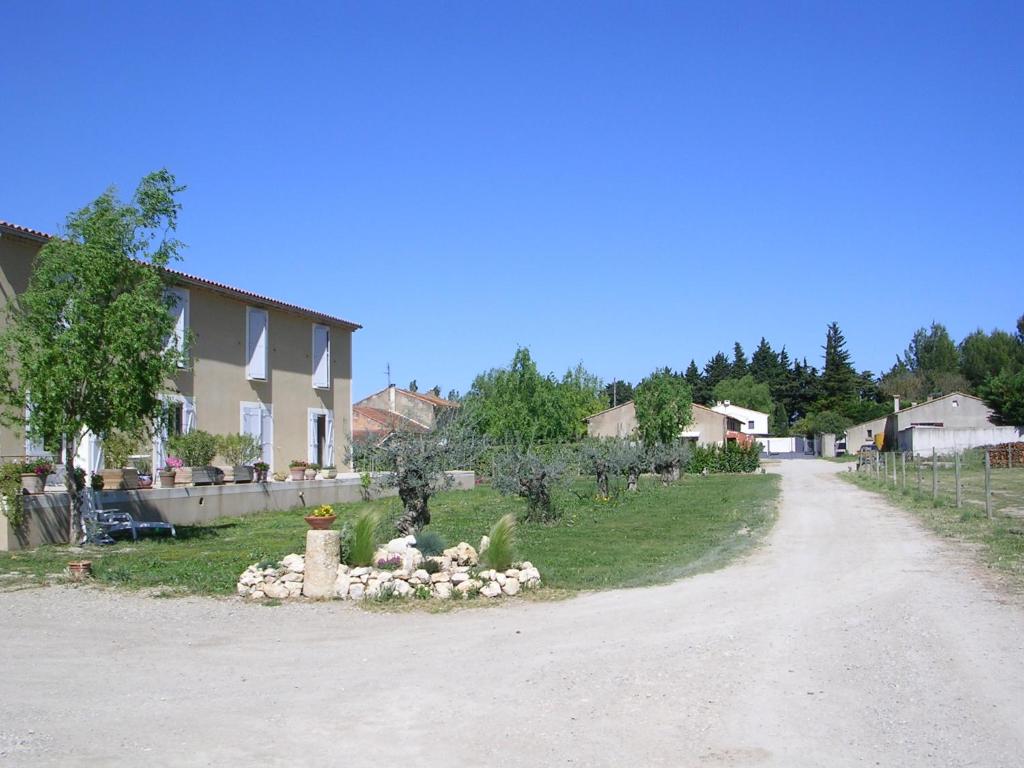 a dirt road with a house and a yard at La Sarriette, Chambres d'hôtes et gîte d'étape à Eygalieres 13810 in Eygalières