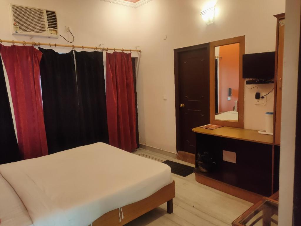 une chambre avec un lit, une coiffeuse et un miroir dans l'établissement Hotel Laxmi Palace, à Dehradun