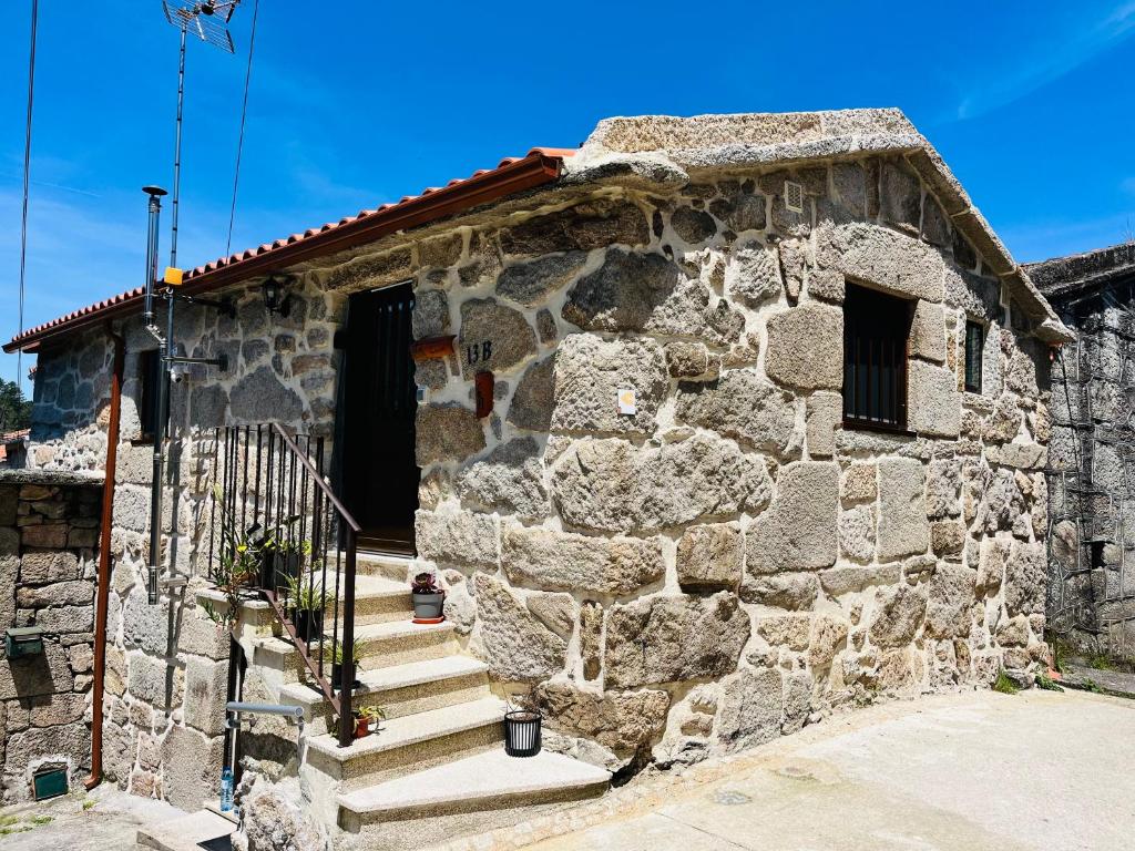 a stone building with stairs leading to a door at Maison L aurore in Lobios