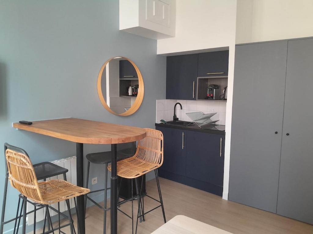 - une cuisine avec une table, deux chaises et un miroir dans l'établissement Superbe appartement moderne idéalement situé, Lyon, à Lyon
