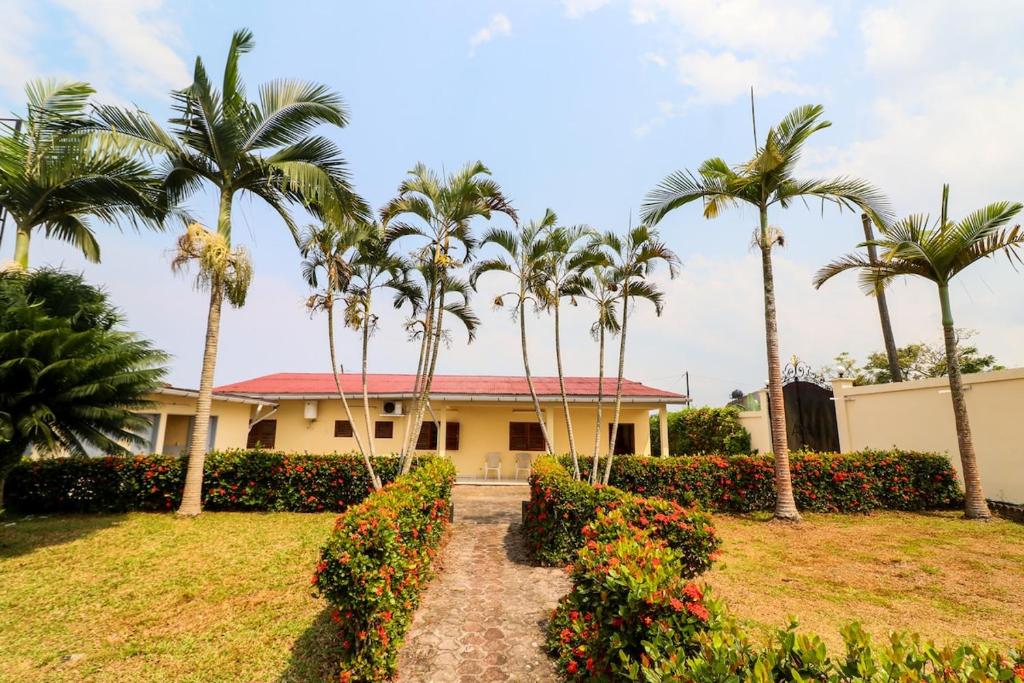 a house with palm trees in front of it at Villa NATH - Kribi centre-ville in Elabi