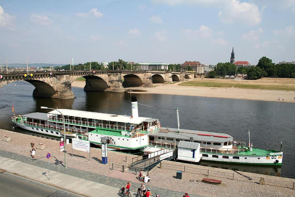 a boat is docked on a river near a bridge at Ferienwohnung Schütze in Dresden