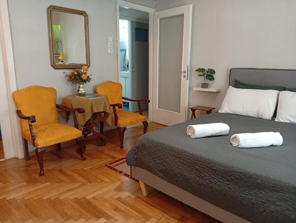ein Schlafzimmer mit einem Bett und zwei Stühlen und einem Tisch in der Unterkunft Smart cozy apartment in Athens! in Athen