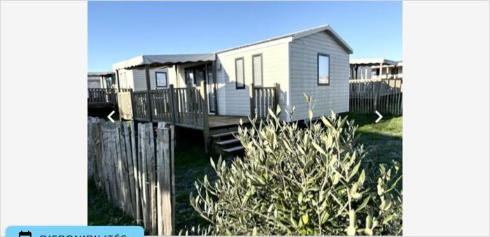 une maison avec une clôture devant dans l'établissement Mobil home Bahia DUO Prenium, à Genouillé