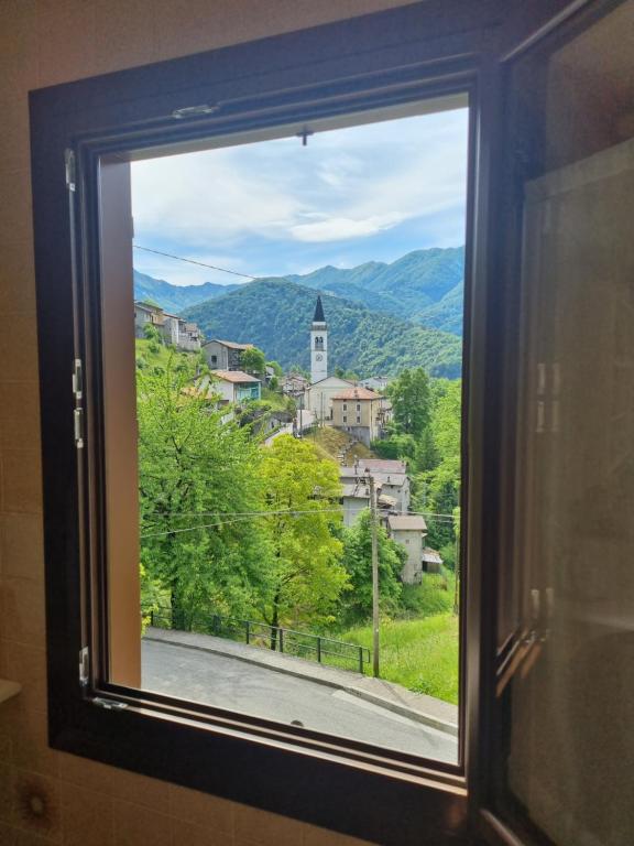 a window with a view of a town at La casa di Anna - Digital Detox in Stolvizza