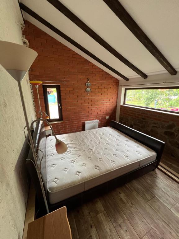 a large bed in a room with a brick wall at Villa SHU in Krimovice