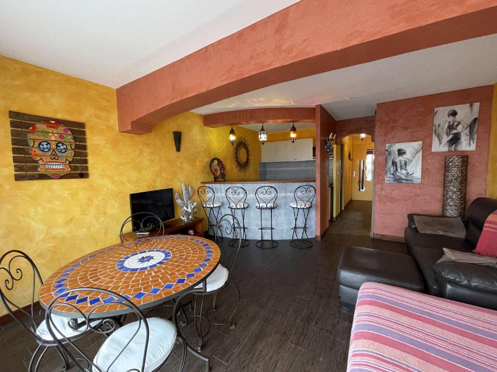 un salon avec une table et une cuisine dans l'établissement CACTUS Natura-Beach NB202 - Luxe - 4 personnes, au Cap d'Agde