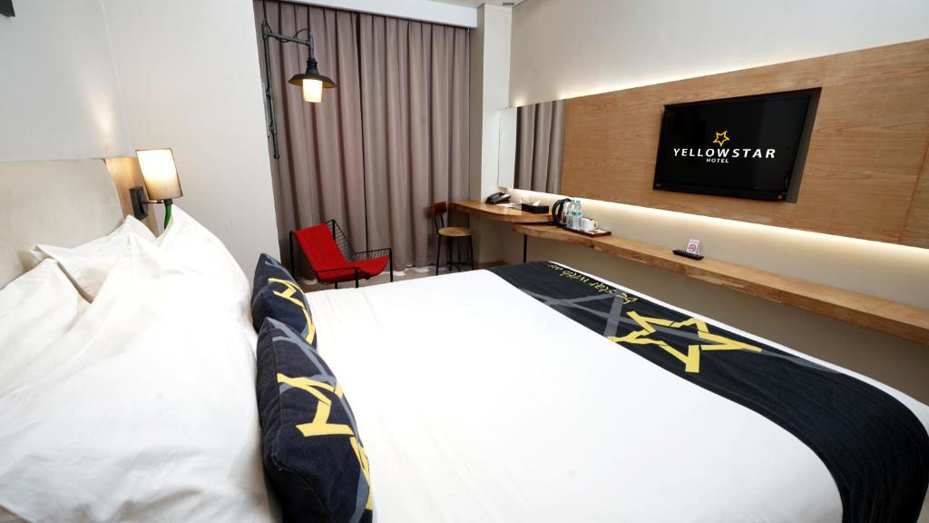 Cama o camas de una habitación en Yellow Star Gejayan Hotel