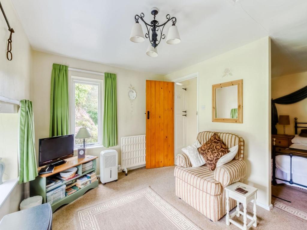 a living room with a couch and a tv at Secluded Holiday Home in Ceredigion with Garden in Pennant