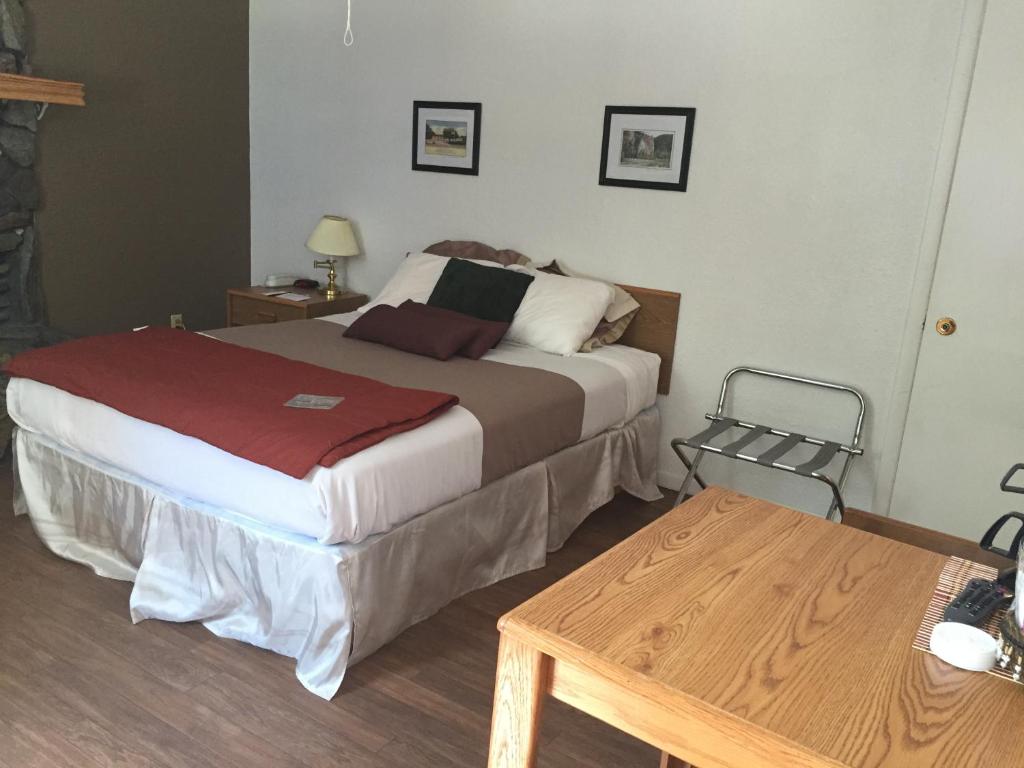 a bedroom with a bed and a wooden table at The Brookside Motel / Mt. Rushmore in Keystone