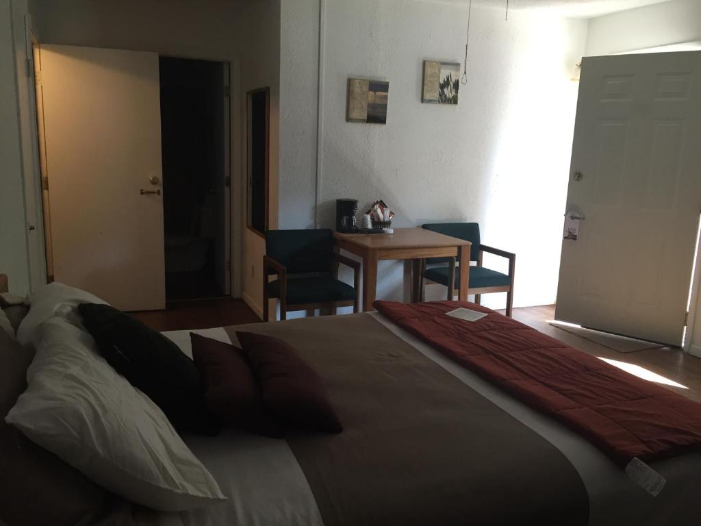 a bedroom with a bed and a table with chairs at The Brookside Motel / Mt. Rushmore in Keystone