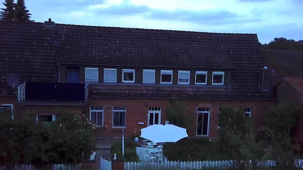 a red brick house with a white fence at Casa Linda in Rotenburg an der Wümme