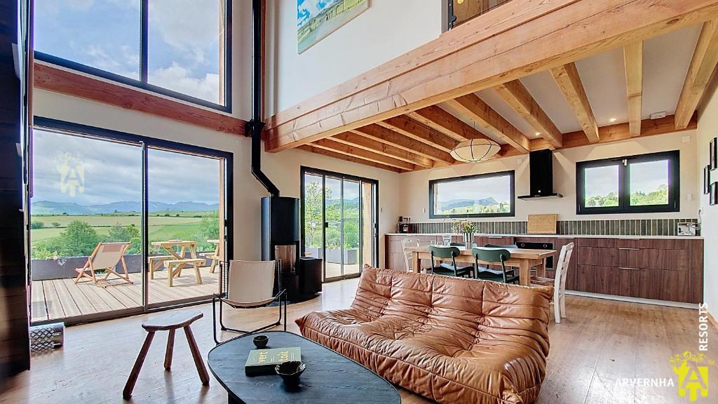 un salon avec un canapé en cuir et une table dans l'établissement Chalet Joie, à Murol