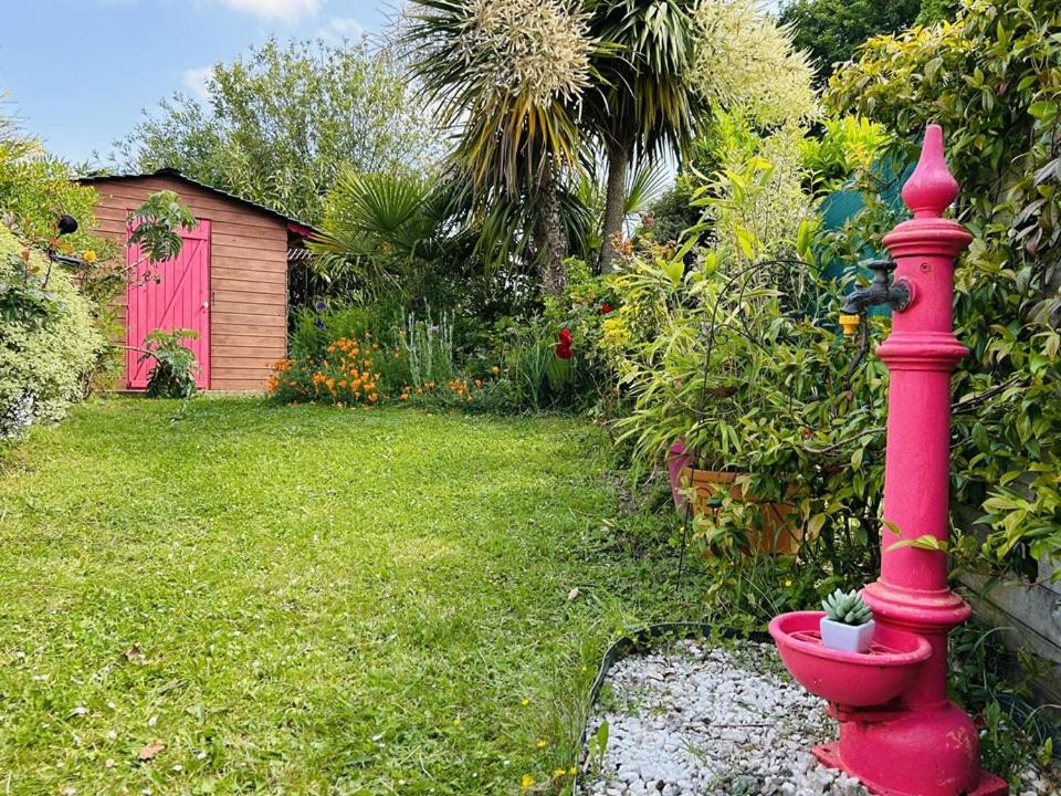 un poteau rouge dans une cour avec une maison dans l'établissement Maison 2 pièces 4 personnes, résidence très calme à 5 mn des plages - Wifi, à Guidel