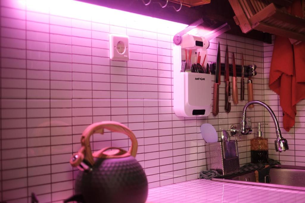 uma cozinha de azulejos rosa com uma pia e um vaso em Abrakadabra Manshon em Timuran