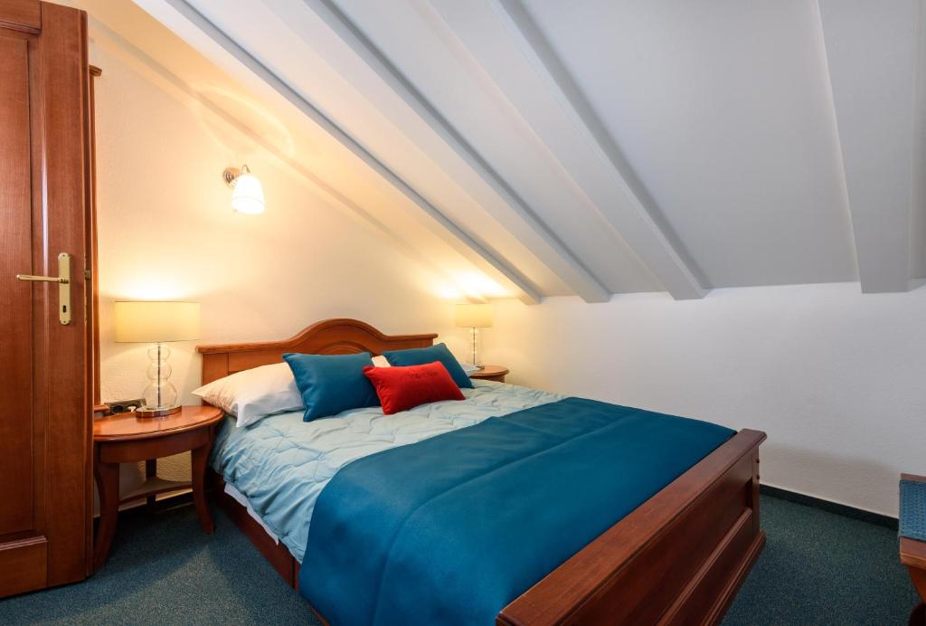 Schlafzimmer mit einem Bett mit blauen und roten Kissen in der Unterkunft Villa Meri in Trogir