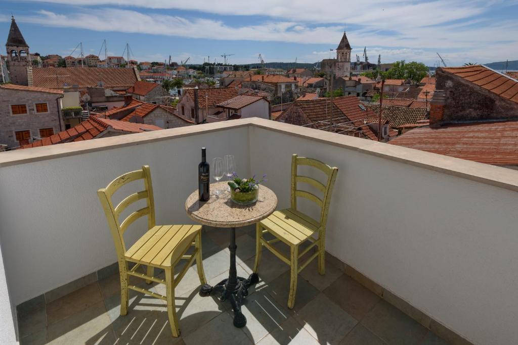 a table and chairs on a balcony with a bottle of wine at Villa Meri in Trogir