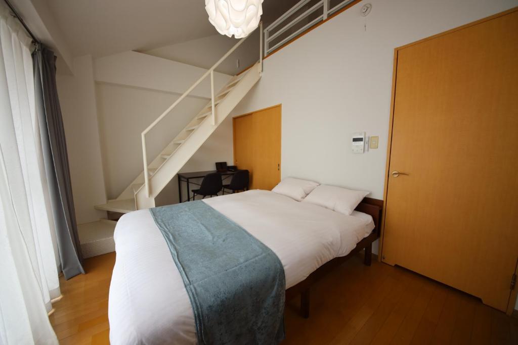 a bedroom with a bed and a stair case at goom Monthly Nakasu Maxim in Fukuoka