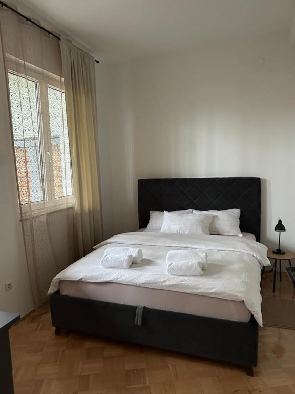 a bedroom with a large bed with towels on it at Apartman Galah in Vukovar